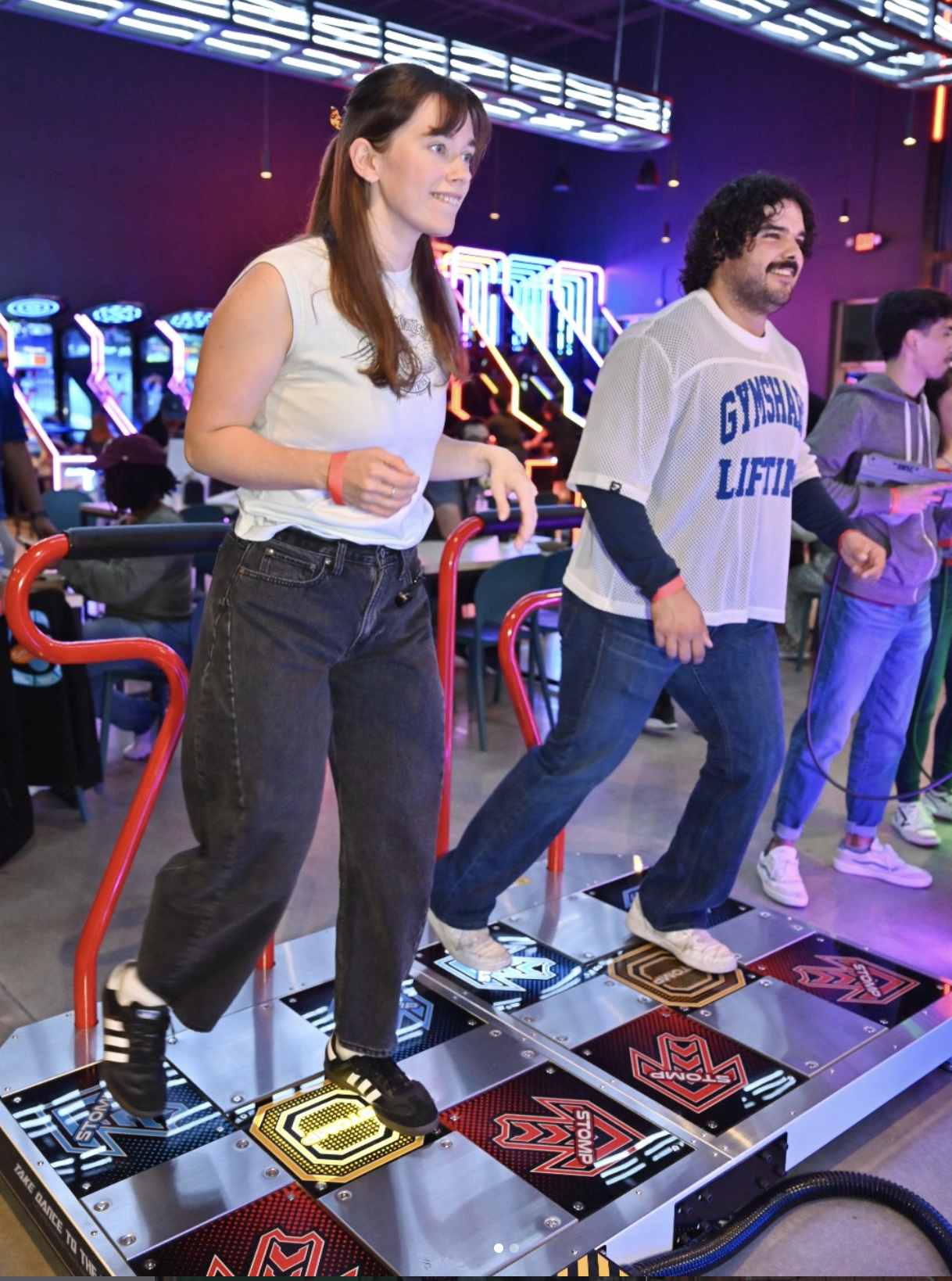 Two adults playing dance arcade games at Taroko